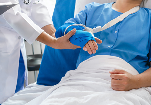 Medical professional tending to a patient with a bandaged arm, illustrating serious personal injuries in Mission, TX